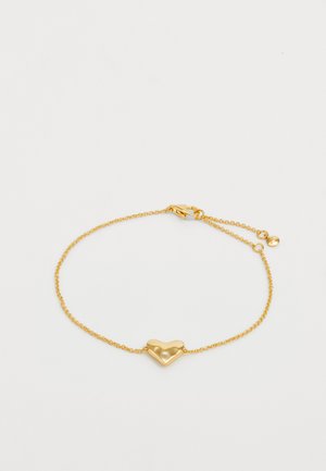 Pulsera de cadena en tono dorado con un charm central en forma de corazón, textura suave y un cierre de langosta con una cadena ajustable.