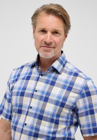 Korte mouwen knoopshirt in een blauw, geel en grijs geruit patroon. Voorzien van een kraag en donkerblauwe knopen. Gemaakt van katoen.