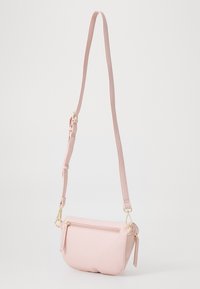 Rozā krusta soma, kas izgatavota no teksturēta materiāla, ar zelta rāvējslēdzēju un regulējamu siksnu. Kompakta, noapaļota forma ar vienu kabatu.