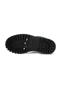 Suela de goma negra con patrones de relieve profundos y acentos elevados. Perfil plano con una superficie texturizada para un mejor agarre. Área del talón reforzada.