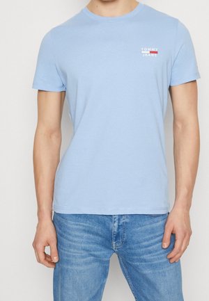 Lyseblå bomuld T-shirt med rund halsudskæring og korte ærmer. Har en lille rød og hvid "TOMMY JEANS" logo på venstre bryst.