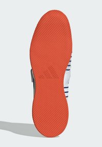 Sko sål med dybt treads mønster i orange gummi, med et centralt logo. Overdel i hvidt stof med blå striber.