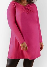 Fuchsiové šaty do kolen s dlouhými rukávy, se zkrouceným uzlem na výstřihu a hladkým, jemným povrchem.
