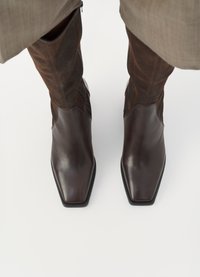 Stivali in pelle marrone con una finitura lucida, design a punta quadrata e tomaia in camoscio marrone a contrasto, dotati di cerniere laterali per la chiusura.