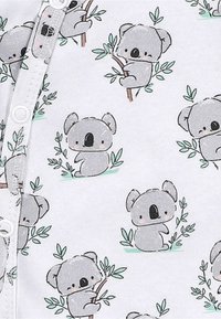 Szary materiał bawełniany z powtarzającym się wzorem kreskówkowych koali siedzących na gałęziach z zielonymi liśćmi, uzupełniony delikatnymi detalami.