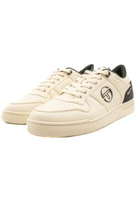 Krémszínű bőrsneakers sima felülettel, fekete akcentussal, perforált orral és logóval az oldalon. Hagyományos fűzős kialakítás.