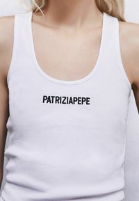 Weißes, geripptes Tanktop mit rundem Ausschnitt und schwarzem Sticktext auf der Vorderseite, der "PATRIZIAPEPE" liest.