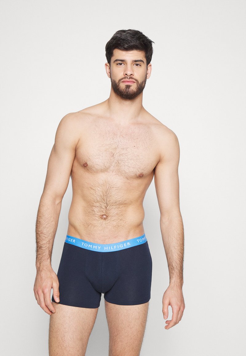 Boxers en coton bleu marine avec une ceinture "TOMMY HILFIGER" bleu clair, offrant une coupe ajustée et des coutures minimales pour plus de confort.