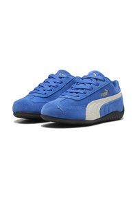 Zapatillas de ante azul con acentos blancos, que cuentan con un diseño de cordones y suelas de goma. Detalles del logotipo en dorado en el lateral y la lengüeta.