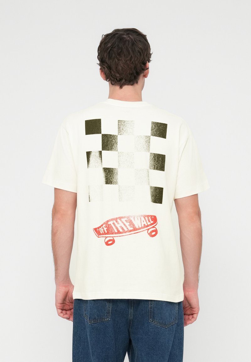 Εκρού T-shirt με μοτίβο σκακιέρας σε πράσινο και άσπρο, με κόκκινο γραφικό skateboard που γράφει «OFF THE WALL» στο πίσω μέρος.