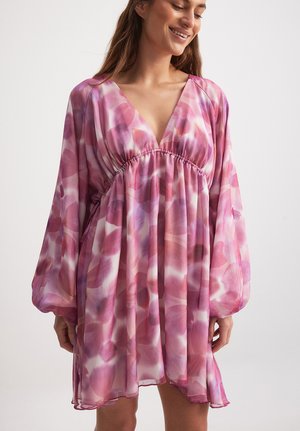 Abito fluido con scollo a V in un motivo floreale rosa e bianco, con maniche lunghe e morbide e una vita arricciata per un fit rilassato.