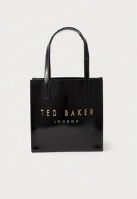 Schwarze Tragetasche aus Lackleder mit goldenem, geprägt "TED BAKER LONDON"-Logo. Quadratförmig, mit zwei Griffen, glatte Oberfläche, minimalistisches Design.