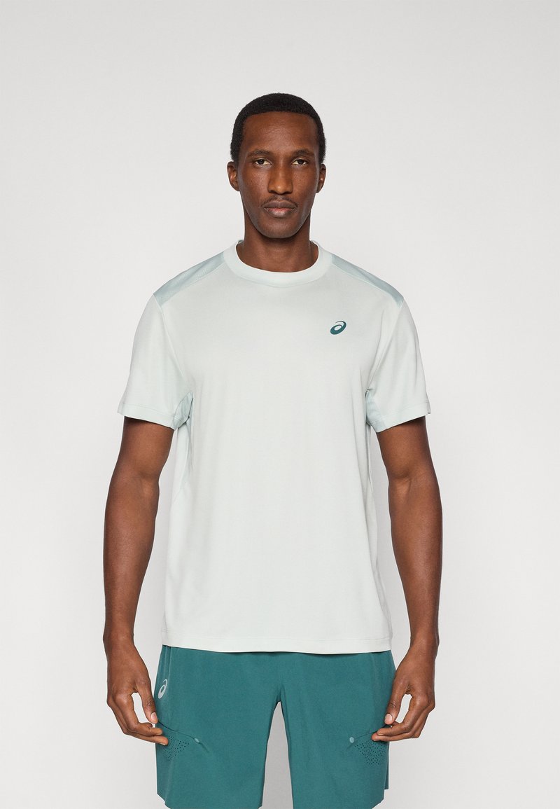 Αθλητικό T-shirt ανοιχτού γκρι χρώματος με κοντά μανίκια, με στρογγυλή λαιμόκοψη και μικρό λογότυπο στο στήθος. Λείο ύφασμα με κανονική εφαρμογή.