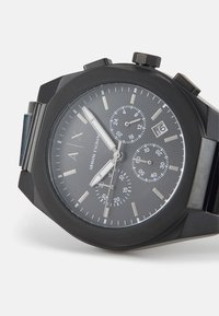Orologio cronografo nero con quadrante grigio texturizzato. Presenta indicatori delle ore in tonalità argento, finestra della data e bracciale in acciaio inossidabile nero.