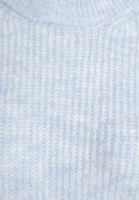 Hellblaues, geripptes Strickoberteil aus weichem, strukturiertem Stoff. Verfügt über einen runden Halsauschnitt und subtile Farb- und Strukturvariationen.
