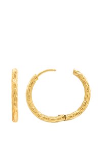 Des boucles d'oreilles en or en forme de créole présentent une texture martelée, une forme circulaire et un fermoir sécurisé. La surface montre des creux irréguliers pour un détail supplémentaire.