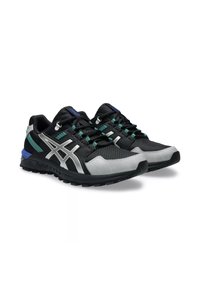 Scarpe da ginnastica nere e argento con materiale in rete, punta nera testurizzata, accenti riflettenti e dettagli blu e turchese sul lato.