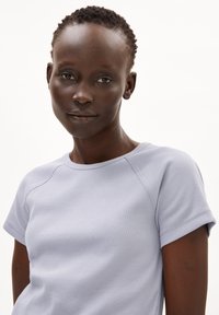 Lichtpaarse geribde t-shirt met een ronde halslijn en korte mouwen. Bevat een gestructureerde stof en subtiele stikdetails.