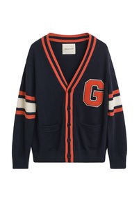 Cardigan navy din țesătură tricotată, cu dungi portocalii și albe pe mâneci, o broșă mare cu litera "G" și două buzunare frontale.