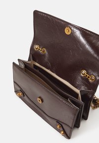 Borsa a tracolla in pelle marrone con finitura texturizzata, hardware dorato, chiusura a patta e più scomparti all'interno. Fascetta a catena visibile.