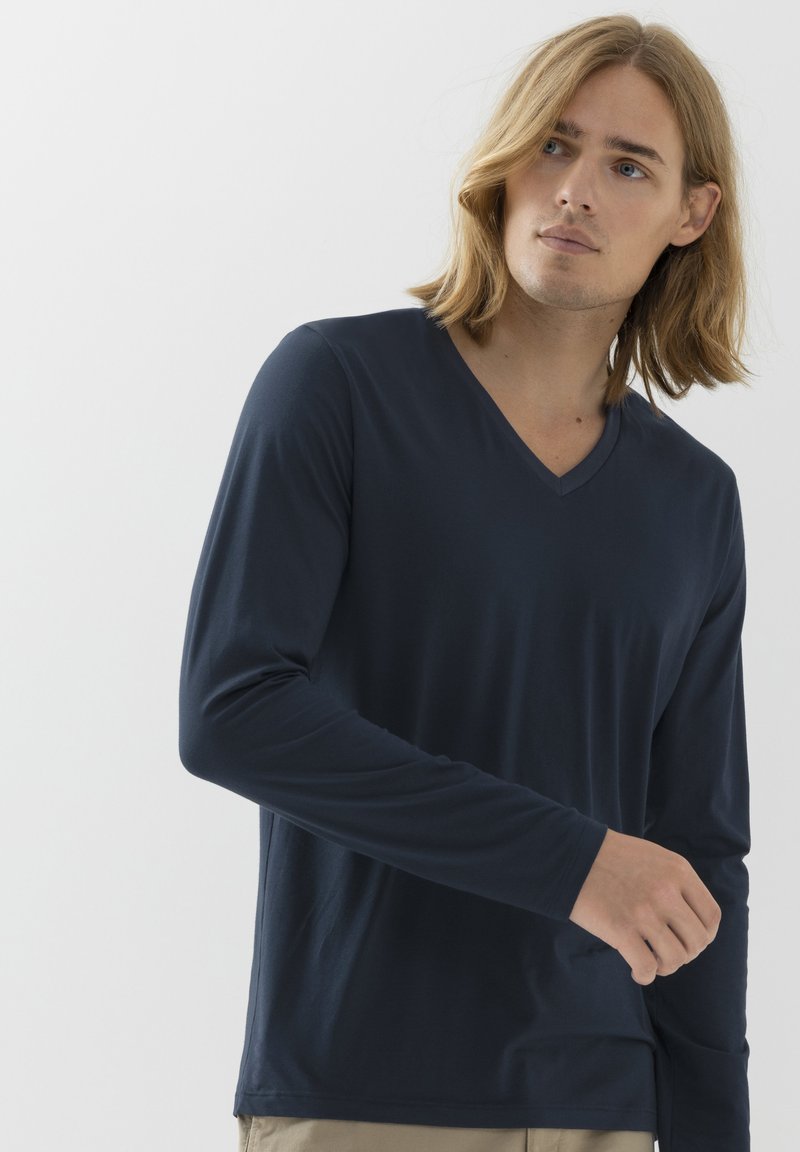 Granatowa koszula z długim rękawem i dekoltem w serek, wykonana z miękkiego, gładkiego materiału. Posiada luźny krój i delikatne rozcięcia po bokach u dołu.