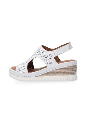 White perforated wedge sandal with an open toe, ankle strap, and textured jute-like detailing on the platform, featuring a foam midsole.