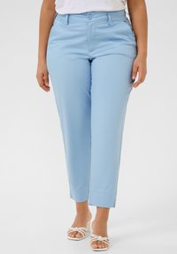 Pantalones de color azul claro, ajustados y con corte recto. Presentan un cierre de botón y bolsillos laterales. La tela tiene una textura suave.