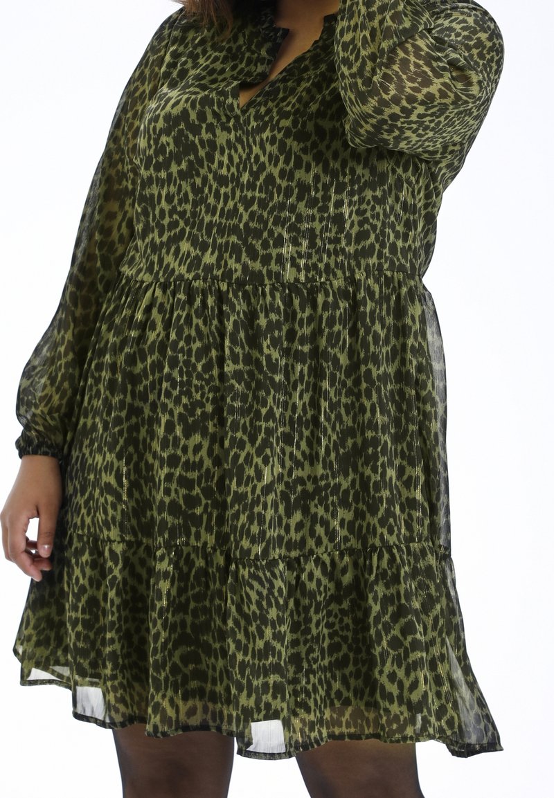 Groene luipaardprint jurk met een gelaagd ontwerp, lange doorschijnende mouwen en een sleutelgat-decolleté. Gemaakt van lichtgewicht, vloeiende stof.