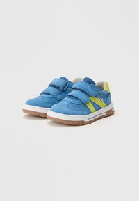 Siniset mokkanahkakengät vaaleanvihrein yksityiskohdin, tarranauhakiinnitys, pehmustettu kaulus ja valkoiset kumipohjat, joissa on kuvioitu pito.