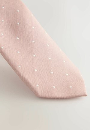 Rózsaszín nyakkendő texturált anyagból, egyenletesen elhelyezett fehér pöttyökkel, hegyes végű és elegáns, modern dizájnnal.