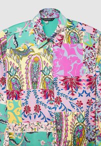 Colorful patterned shirt featuring floral and paisley designs in shades of pink, green, yellow, and blue; includes a collar and buttons.
