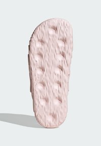 Gumená podrážka sandálov v svetloružovej farbe, textúrovaná s ryhami a kruhovými preliačinami pre lepší grip. Zaoblený špic s mierne zvýšeným opätkom.