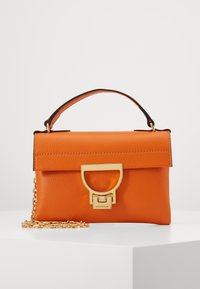 Borsa a mano in pelle arancione con forma strutturata, manico superiore, dettagli in oro, tracolla a catena e chiusura magnetica. Finitura testurizzata.