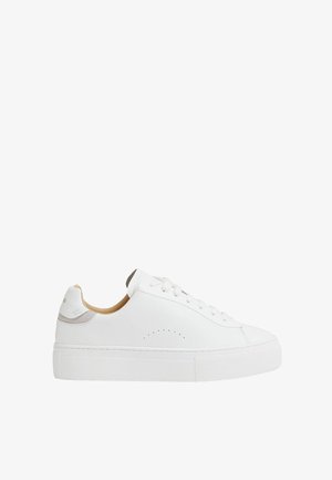 Weißer flacher Ledersneaker mit weißen Schnürsenkeln, perforierten seitlichen Details, beiger Innenauskleidung und dicker strukturierter Gummisohle.