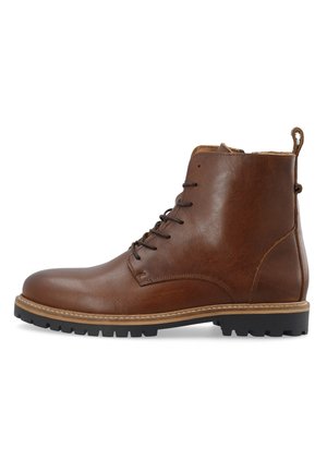 Botas de cuero marrón por el tobillo con un acabado suave, acentos de costura en contraste, puntera redonda y una suela de goma resistente para mayor tracción.