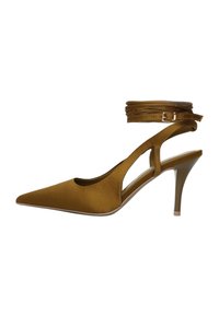 Chaussure slingback à talon haut en daim marron avec un bout pointu, des côtés découpés et une fine bride à la cheville. Dotée d'un talon stiletto modéré.