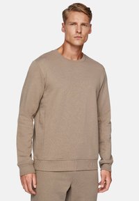 Beige crewneck sweatshirt in soft fabric, featuring ribbed cuffs and hem, with a relaxed fit and seamless design.