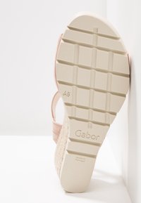 Sandale en suede rose avec une semelle plateforme tissée beige texturée. Dispose d'une semelle en caoutchouc pour une meilleure adhérence et du logo Gabor au bas.