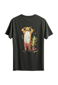 Zwarte katoenen T-shirt met een grafisch ontwerp van een persoon in een tijger onesie, met een bloempot op de achtergrond. Korte mouwen en een relaxte pasvorm.