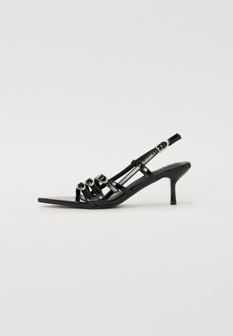 Sorte slingback høyhælte sko med spiss tå, med flere smale stropper og sirkulære detaljer over fronten.