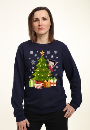 Marineblå sweatshirt med grafik af et pyntet juletræ, gaver, snefnug og en tegneseriefigur. Fremstillet af blødt materiale.