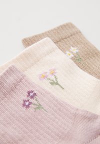 Set di tre calze lavorate a maglia in beige, rosa pallido e malva con ricami floreali. Texture morbida e polsini a costine.
