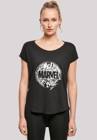 Juoda trumpomis rankovėmis marškinėliai pagaminti iš minkštos medžiagos, su balta apvalia grafika, kurioje yra užrašas "MARVEL" ir komiksų personažai.