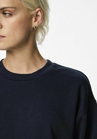 Felpa di cotone blu navy con collo girocollo e spalle scese, caratterizzata da una texture liscia e dettagli di design minimalisti.
