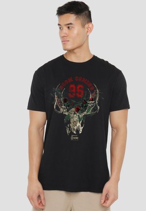 Black cotton t-shirt featuring a graphic design with a skull, antlers, and floral elements in red and green, labeled "DOOM COMING 96."