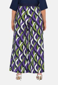 Pantaloni a gamba larga con un motivo colorato di curve viola, verdi e bianche su uno sfondo blu navy. Il materiale sembra leggero con una consistenza liscia.