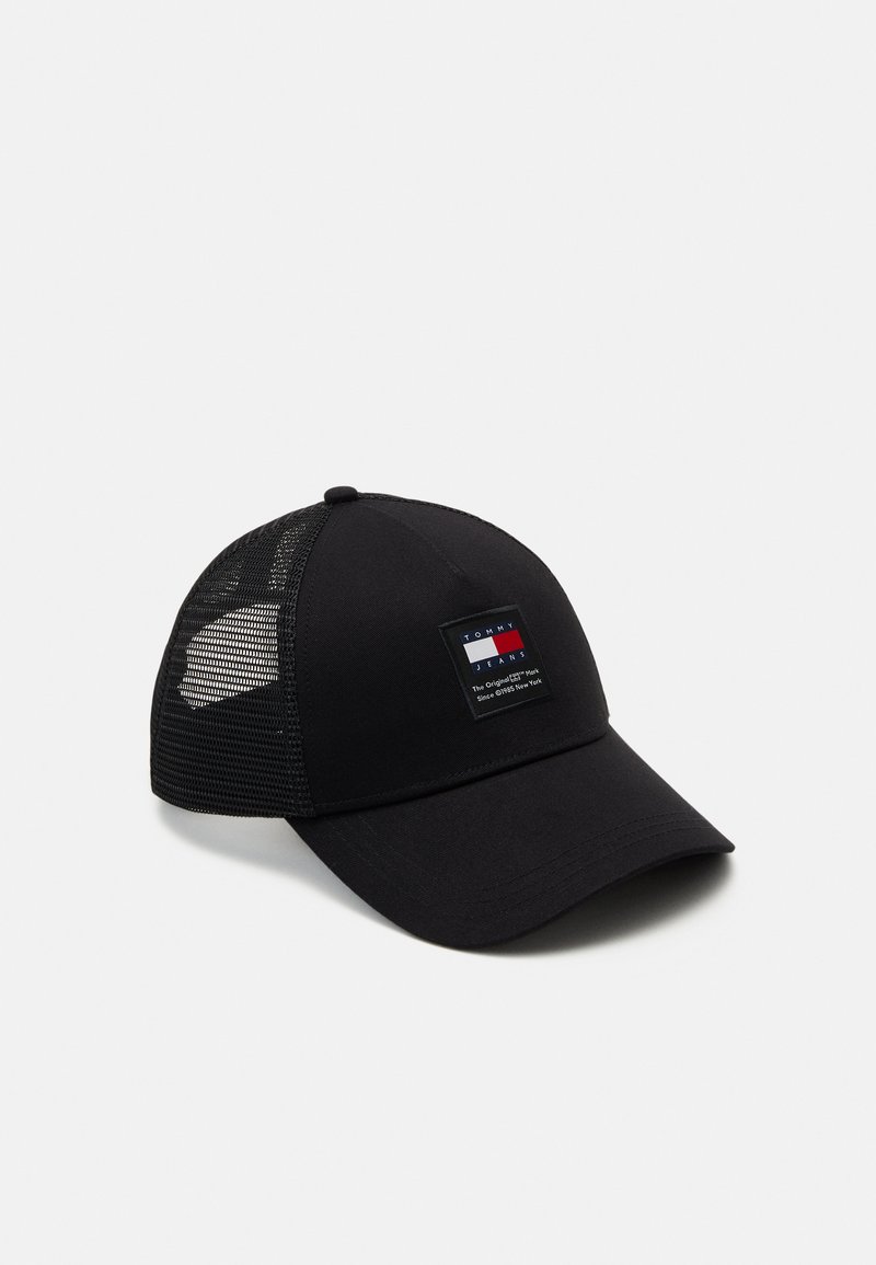 Gorra negra con un frente sólido y lados de malla. Presenta un parche de logo rectangular en rojo, blanco y azul en la parte frontal. Visera curva.