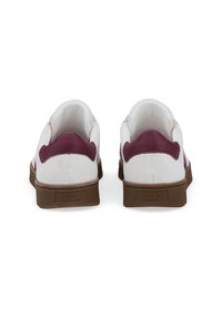 Sneaker bianche e borgogna con tomaia in suede e pelle, suola in gomma marrone e logo sul tallone. Design minimalista, forme arrotondate.