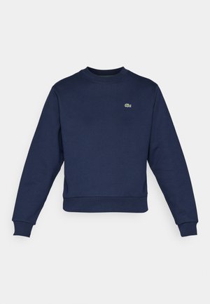 Navy blue sweatshirt made of soft fabric, featuring a crew neckline and ribbed cuffs. Small green Lacoste logo on the chest.
