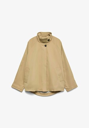 Veste beige à manches longues avec col montant, deux boutons noirs, poches avant et ourlet légèrement arrondi, posée à plat sur un fond blanc.